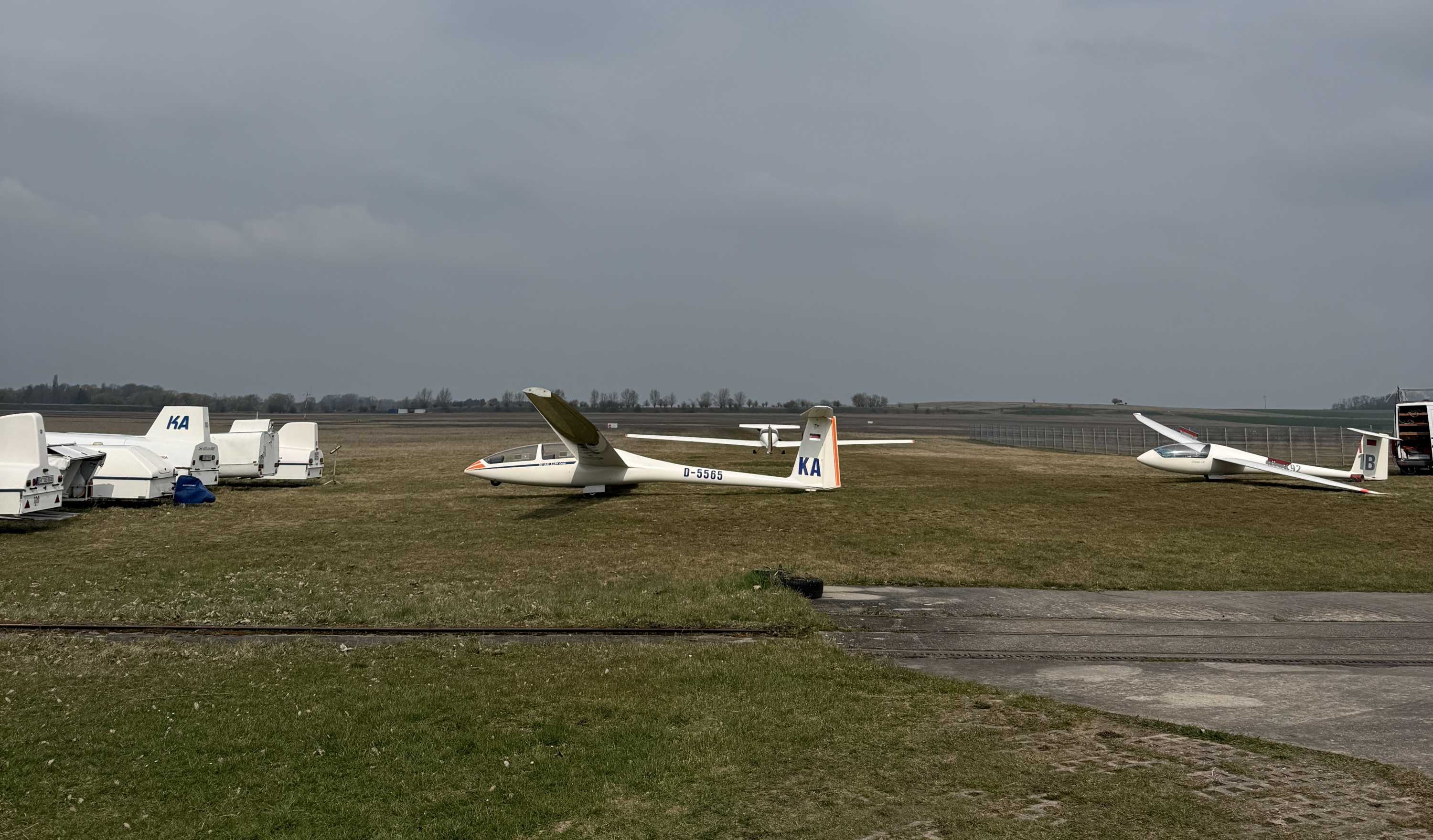 2 Segelflugzeuge stehen aufgerüstet vorm Hangar, links daneben sieht man die Anhänger wo diese drinnen waren